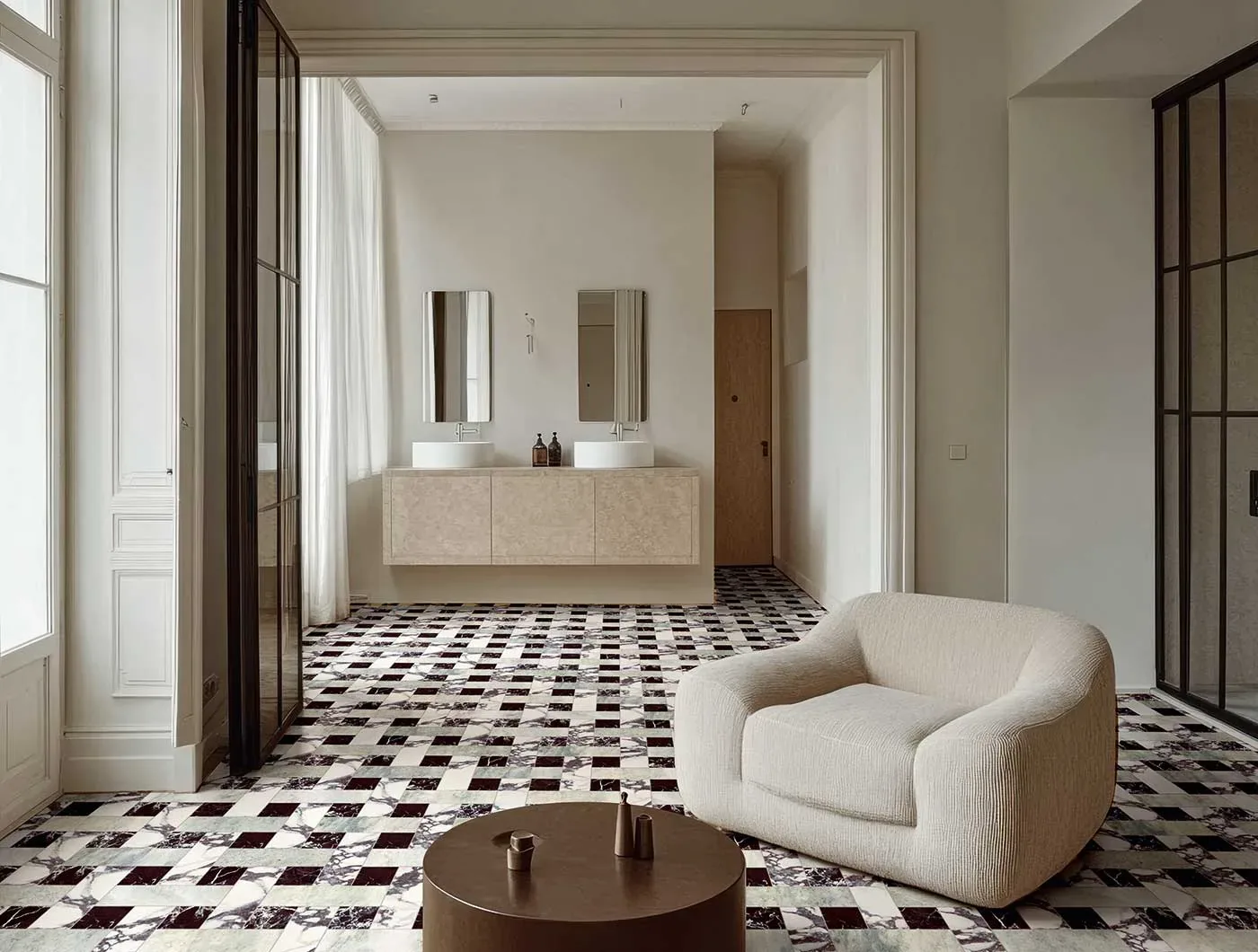 Sol en marbre motif vannerie Calacatta Viola, Rosso Lepanto et Verde Perla dans une suite avec salle de bains, fauteuil bouclé crème